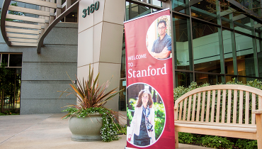 Red vertical Stanford welcome banner outside of the Welcome Center at 3160 Porter Drive
