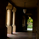 Silhouette of person walking along dark Memorial Quad hallway with shadows and light