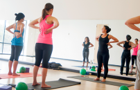 Participants following instructor in a HIP yoga or pilates class.