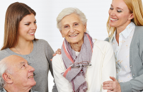 Two female caregivers with an eldery couple.