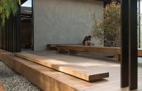 Student reading in the external courtyard of Japanese-influenced modern architecture