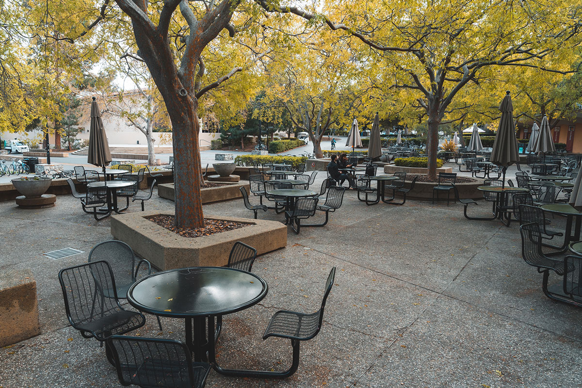 Empty tables and chairs in outside dining area.