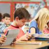 elementary school students reading at classroom desks