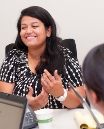 photo of female employee smiling while in discussion with another colleague