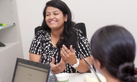 photo of female employee smiling while in discussion with another colleague