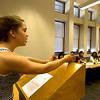 Stanford student giving a presentation at the podium with class members in the background.