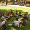 Students sitting in a circle on the grass. 