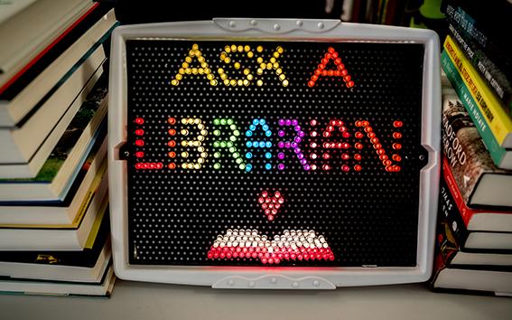 Ask a Librarian spelled out in a lightbox with glowing, multi-colored pegs.