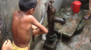 A boy uses drinking water handpump in Dhaka, Bangladesh