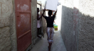 A resident of a slum in Cap Haitien, Haiti carries a dry toilet developed by Stanford engineers.