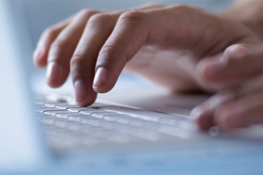 hands typing on laptop computer