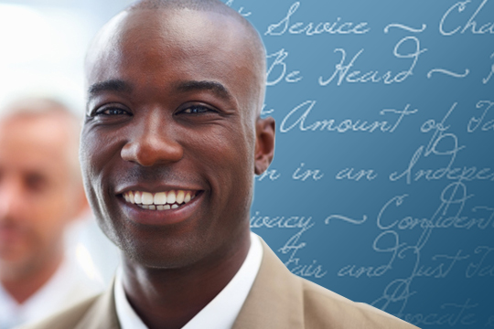 A smiling man standing in front of a chalkboard