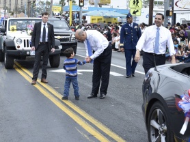 During the International Bridge Ceremony parade, a child runs up to greet Secretary Jeh Johnson.