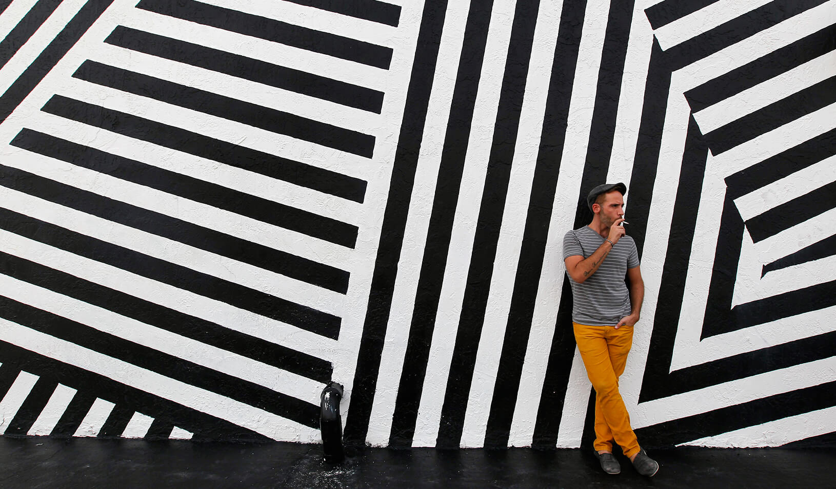 A man smokes a cigarette outside a building in Wynwood, a Miami neighborhood transformed by an influx of artists and visionary real estate developers | Reuters/Andrew Innerarity