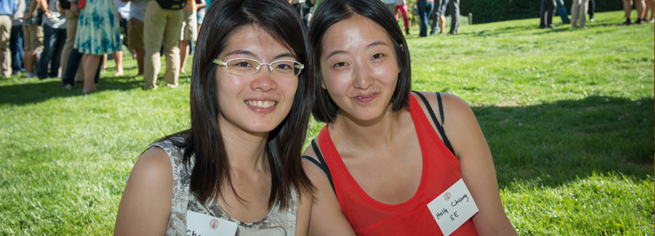 Two students sitting on the grass during a summer conference