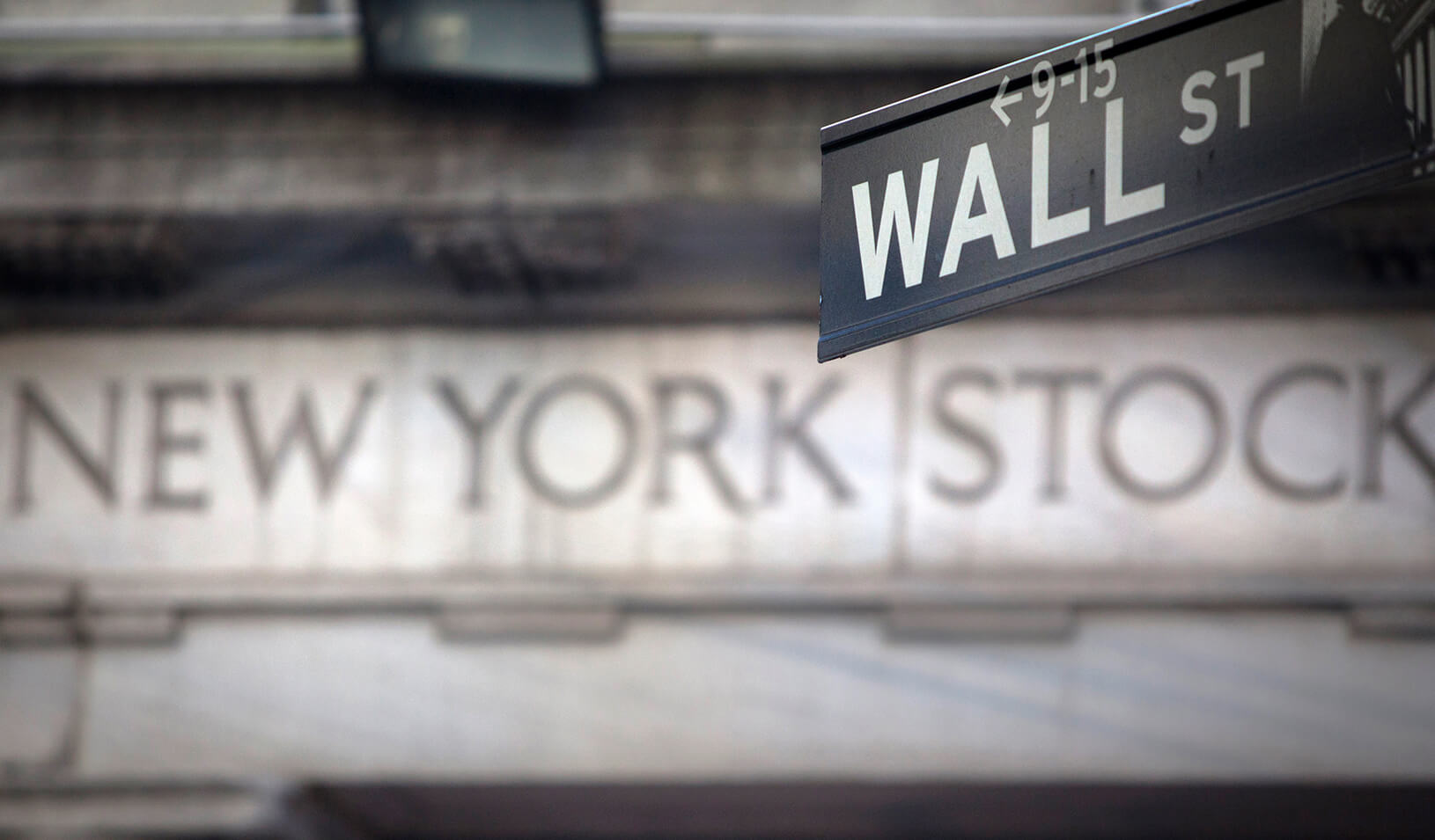 A "Wall Street" sign overlooking the New York Stock exchange | REUTERS/Carlo Allegri 