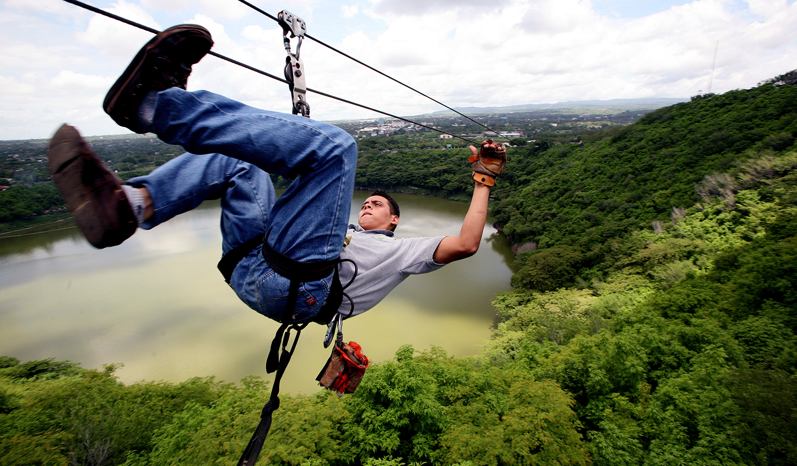 Man zip lining over a forest 