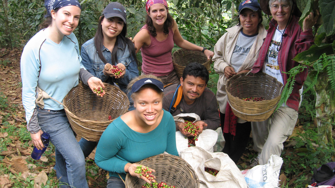 Students with workers and coffee beans during study trip to Guatemala