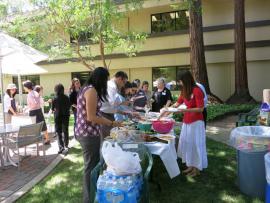 Attendees getting food at Staff Groups Summer Potluck July 2014
