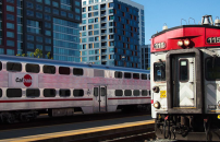 Caltrain arriving to station in San Francisco, tracks next to skyscrapers.