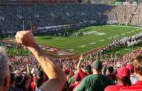 Fans in audience cheer on Stanford's football team at the Stanford Stadium.