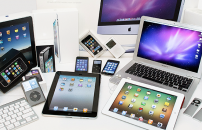 Various Apple products displayed on table: tablets, laptops, phones, etc.