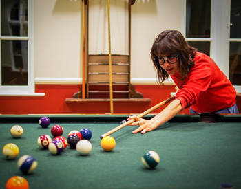 Student playing a game of pool at The Axe and Palm.