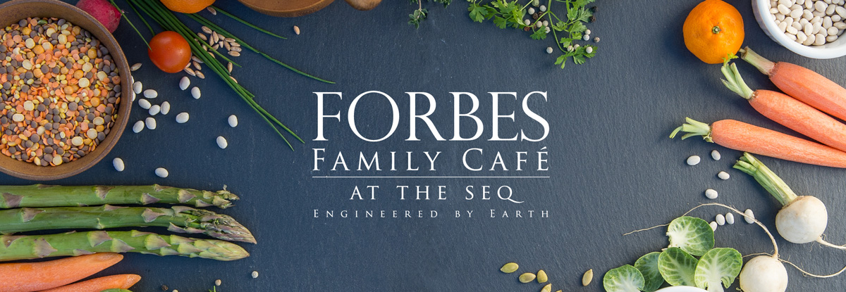 Seeds, fruit and vegetables surrounding the Forbes Family Cafe Logo