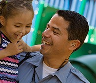 close up photo of Israel Magallon in uniform and holding his daughter