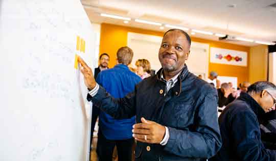 older gentleman participating in a white board session of an Executive Education class