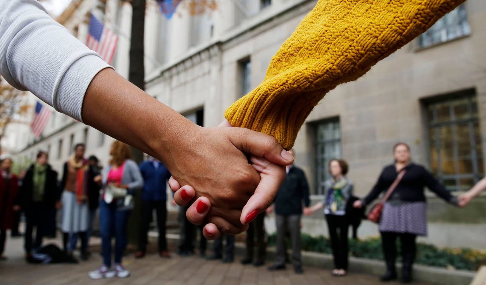 A circle of protestors holding hands | Reuters/Larry Downing