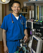 Dr. Cholawat Pacharinsak standing next to an anesthetic machine