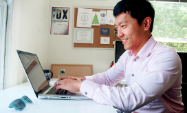 Photo of staff member at desk with computer