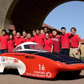 Students standing with solar car on Stanford campus