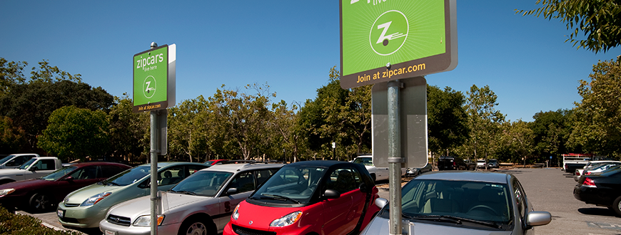 Designated Zipcar parking section with green signs on campus.