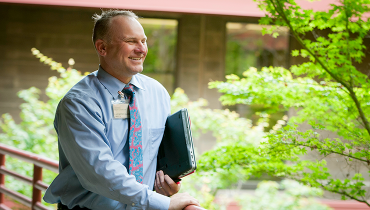 Male staffer carrying laptop en route to a meeting.