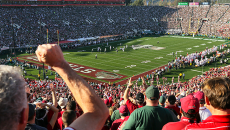 Fans in audience cheer on Stanford's football team at the Stanford Stadium.