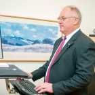 Senior male staff member in suit and tie working at desktop computer