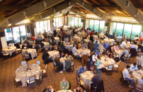 Wide angle view of the Faculty Club interior, with a big gathering of people enjoying a banquet.