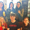 Six students posing with reusable coffee cups