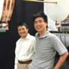Professor Shanhui Fan (left) and graduate student Sid Assawaworrarit standing by a device that wirelessly transmits energy to moving objects