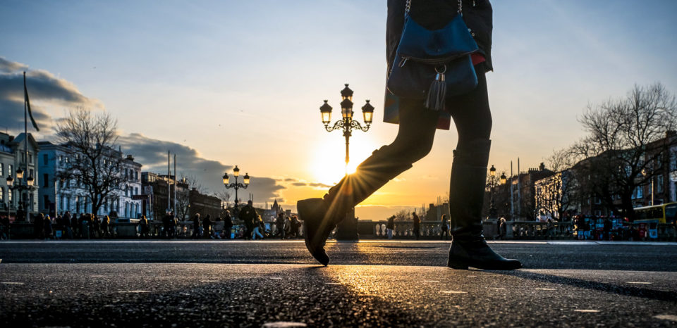 A pedestrian walks across O'Connell Bridge in Dublin, Ireland.