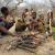 a group of members of the Hazda population in Tanzania, around a fire