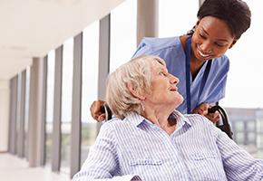 Elderly patient in a wheelchair with her nurse