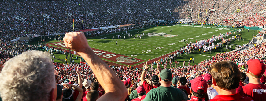 Fans in audience cheer on Stanford's football team at the Stanford Stadium