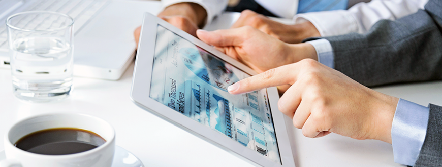 Two people working on laptop and tablet