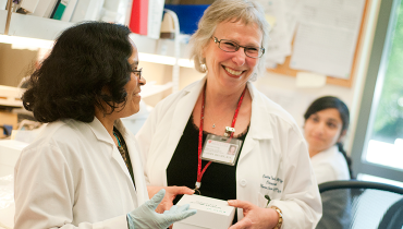 Female medical staff member smiling with colleagues