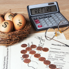 Coins in arrow shape pointing to nest egg, glasses and calculator with word "Retire" on screen