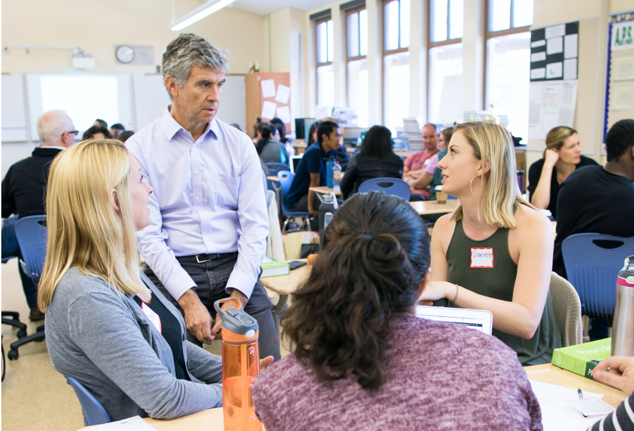 Dan Schwarz having a discussion with attendees at a table.