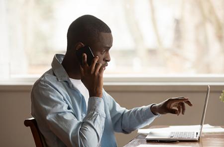 guy looking at screen and talking on phone